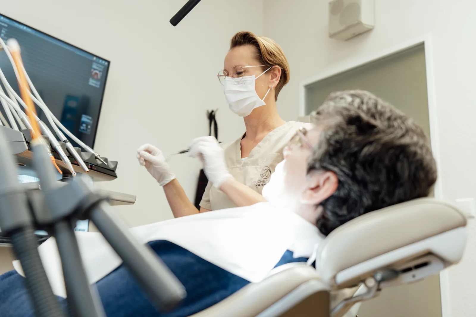 Konzentrierte Behandlung einer Patientin im hellen Behandlungsraum