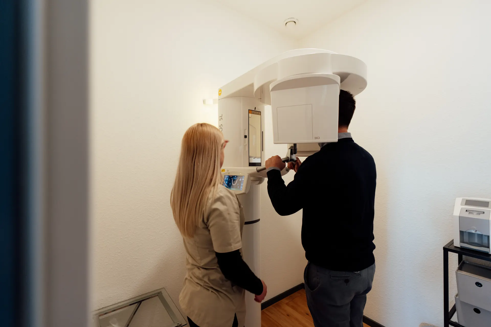 Vorbereitung der DVT-Aufnahme im Stehen — Patient mit Beißstück und sanften Laser-Justierlinien